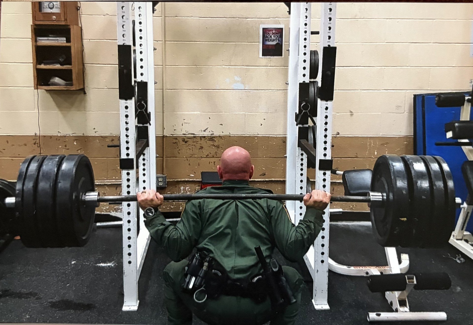 Uniformed officer performing a heavily loaded back squat